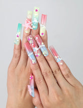 Hand gesture showcasing Singapore handmade long pipe press on nails with 3D floral art, ocean wave designs, and gold starfish accents by Naillover